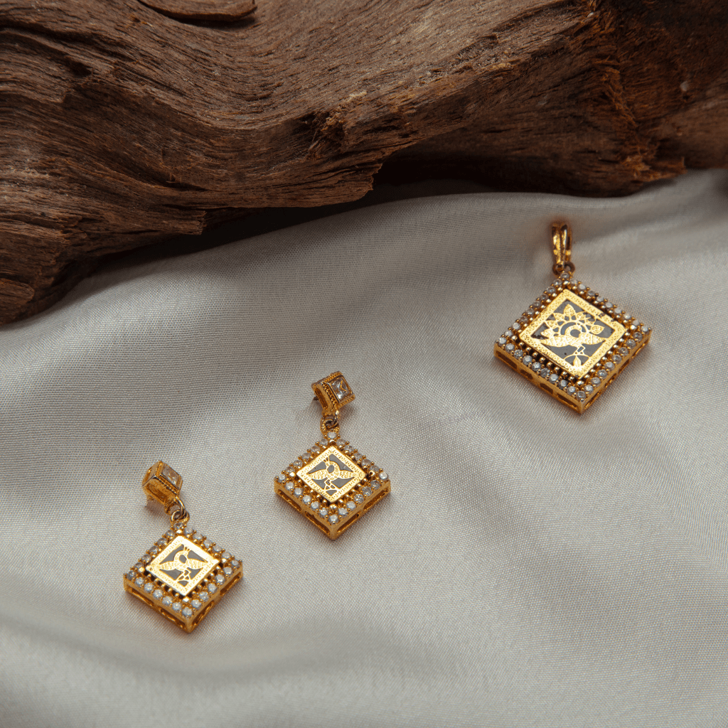 Golden Radiance Pendant Set by Gift Elegantly boasts a gold finish, diamond embellishments, and a bird carving in a square shape. Perfect for special occasions. Treat yourself or gift to someone special.