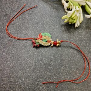 Red Green Jardosi Rakhi featuring intricate Jardosi work, a beautiful stone centerpiece, and delicate pearls