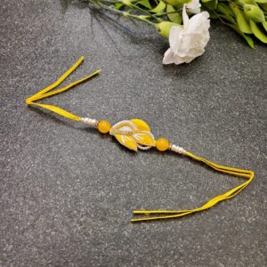 Yellow Resham Stone Rakhi featuring intricate Resham work, a beautiful stone centerpiece, and delicate pearls