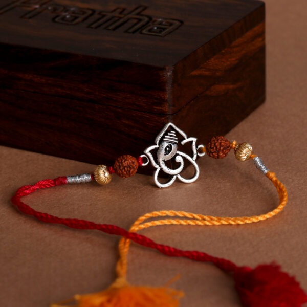 Ganesh Rudraksh Silver Rakhi with vibrant red and yellow threads