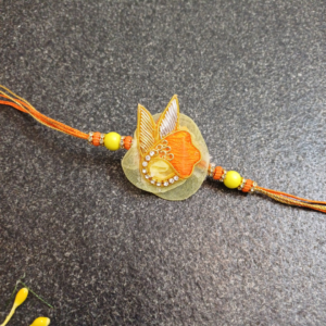 Orange Yellow Stone Rakhi featuring intricate Jardosi and Resham work with a beautiful stone centerpiece