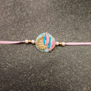 Pink Blue Jardosi Rakhi featuring intricate Jardosi and Resham work with delicate pearl beads