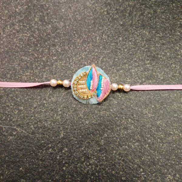 Pink Blue Jardosi Rakhi featuring intricate Jardosi and Resham work with delicate pearl beads