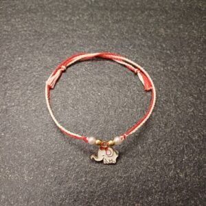Ivory elephant enamel charm rakhi on red-white resham thread with bead accents