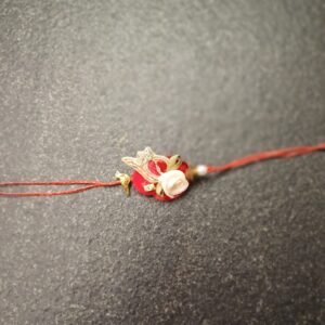 White Rose Resham Rakhi with floral design and crown motif on red thread