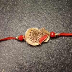 Golden Bloom Resham Rakhi with floral motif and red beads on beige base