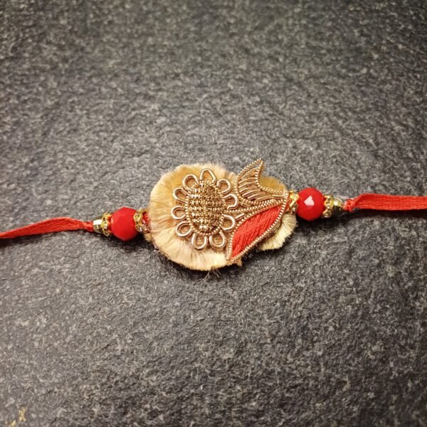 Golden Bloom Resham Rakhi with floral motif and red beads on beige base
