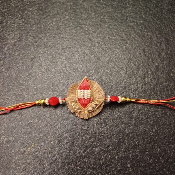 Handmade Sacred Leaf Resham Rakhi with red thread and pearl detailing