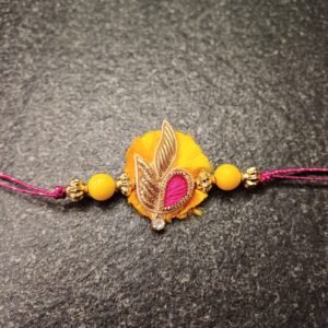 Sunlit Grace Resham Rakhi with yellow base, golden leaf motif and pink thread heart