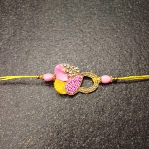 Golden Loop Resham Rakhi with pink beads and yellow resham thread, handmade for Raksha Bandhan.