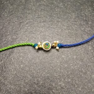 Peacock Charm Resham Rakhi with green-blue thread and peacock feather charm