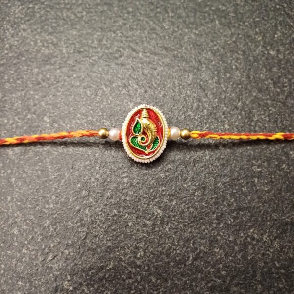 Red resham thread rakhi with enamelled Lord Ganesha centerpiece and roli-chawal pouch