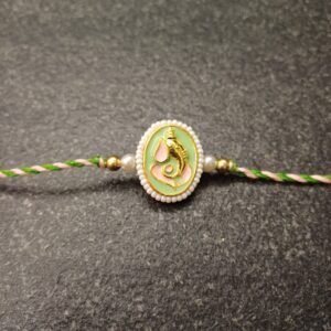 Ganesh enamel rakhi with pearl edging on resham silk thread