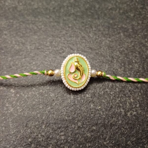 Ganesh enamel rakhi with pearl edging on resham silk thread