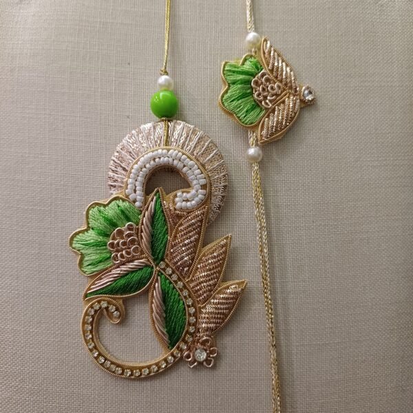 Handmade embroidered green and gold rakhi pair for bhai and bhabhi with floral design