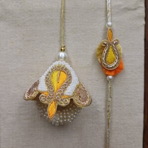 Embroidered pearl rakhi pair with golden paisley design and thread lumba for Raksha Bandhan