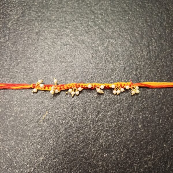 Dangling Pearl Moli Rakhi with red and orange thread and pearl cluster detailing