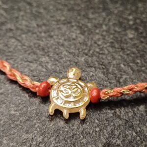 Om Turtle Moli Rakhi with golden turtle charm on red and gold moli thread